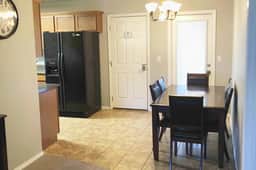 The dining area has a table and seating for six and is adjacent to the living room and kitchen.  The doors to the backyard and garage/gym are pictured.