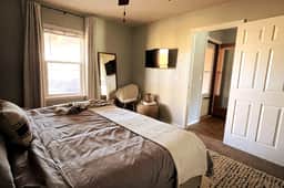 King bed with Amazon FireStick TV in room as well as attached bathroom.