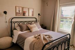 Queen size bed with sun-blocking curtains and pull down blinds.