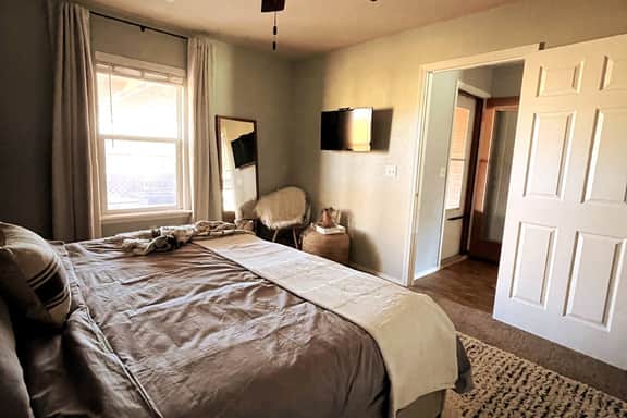King bed with Amazon FireStick TV in room as well as attached bathroom.